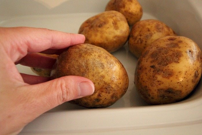 Placing potatoes into a slow cooker