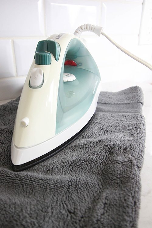Pressing a clean iron on a fresh towel