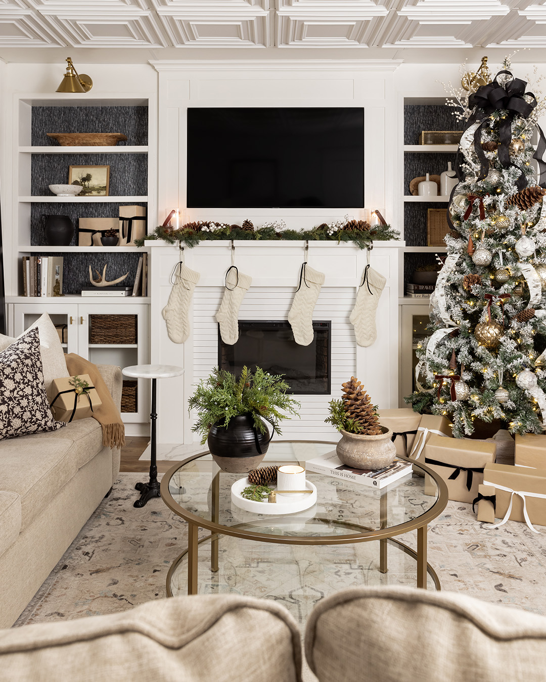 A black bow Christmas tree topper in a neutral living room.