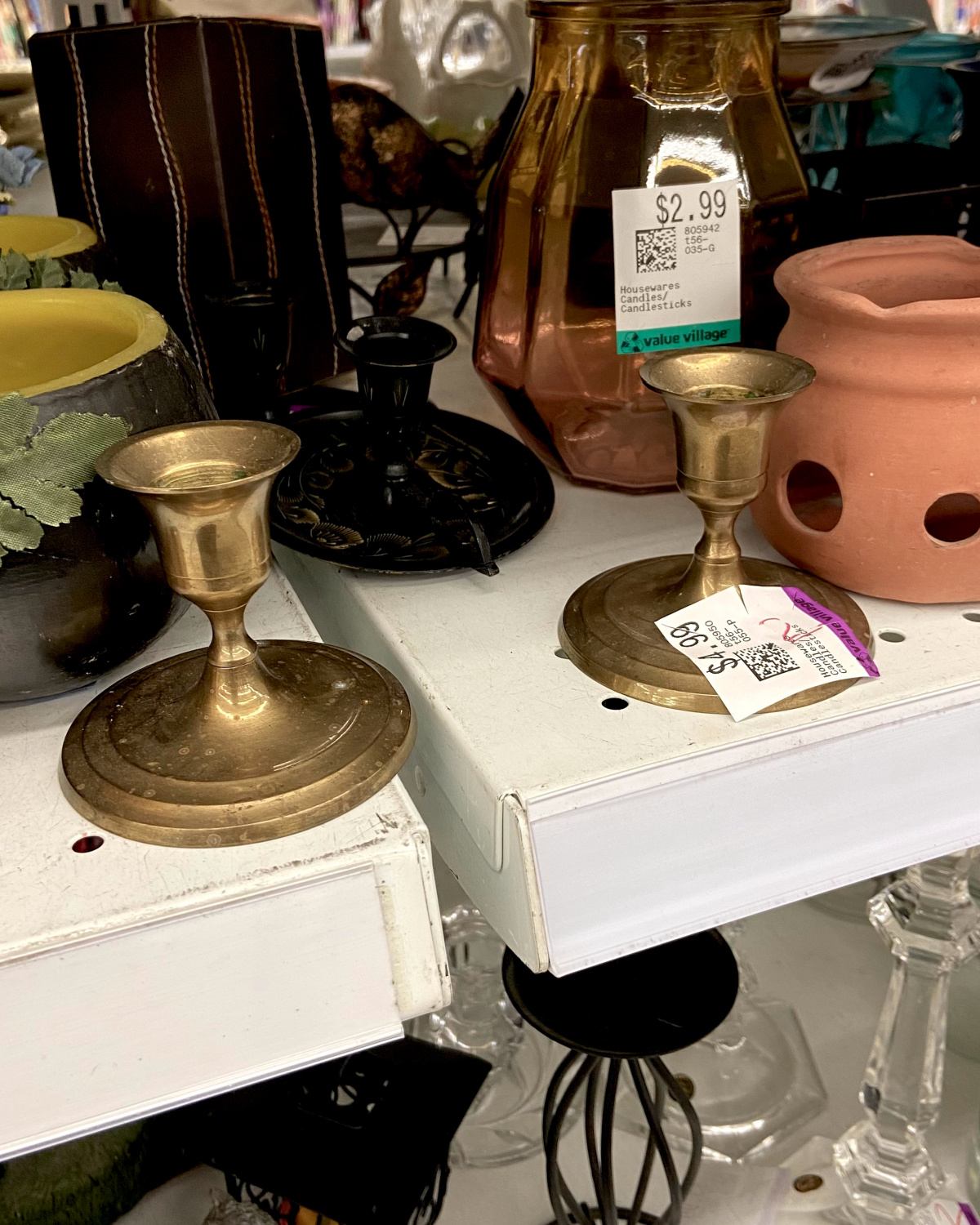 Brass candlesticks on a thrift store shelf.