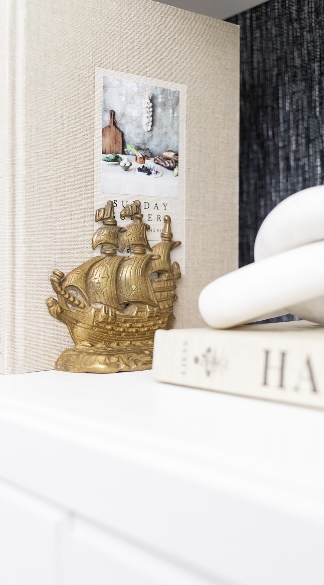 Brass ship bookends displayed with cookbooks.