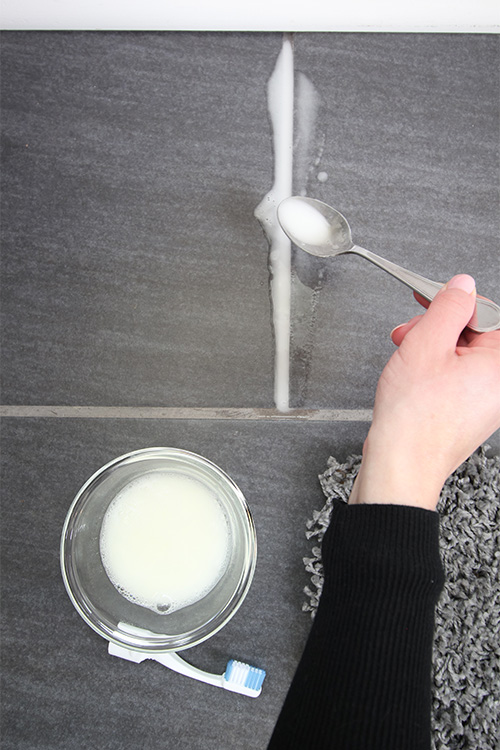 Applying cleaning solution to grout.