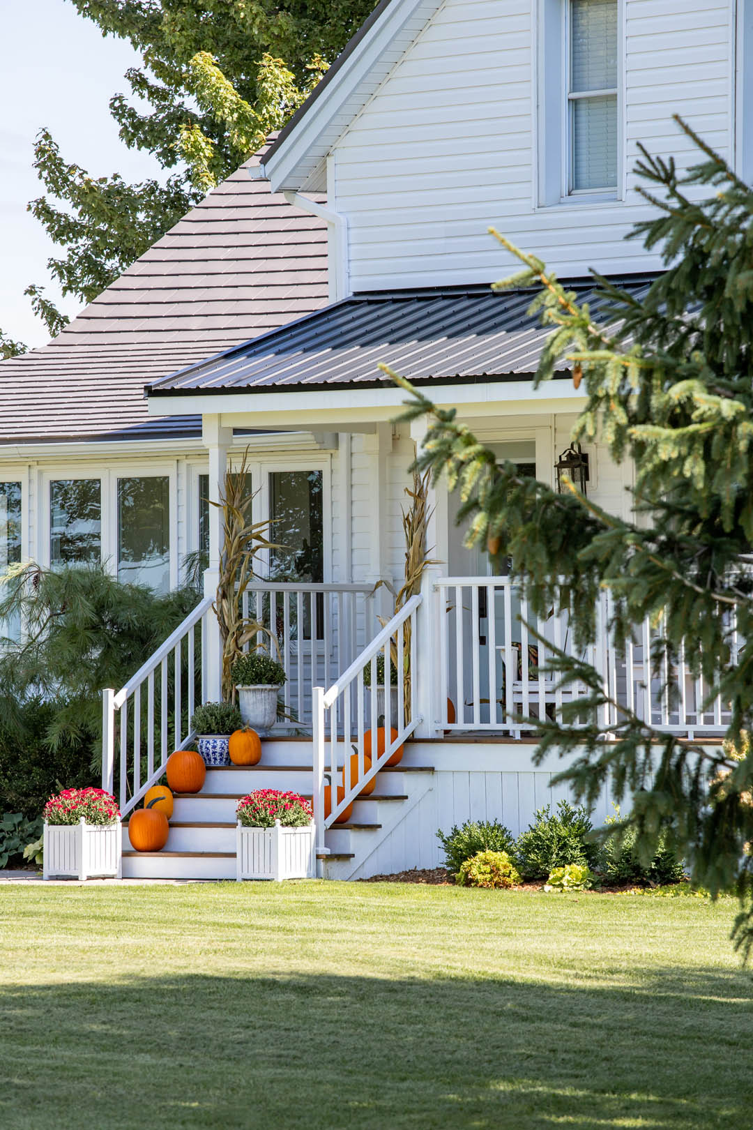 Fall weather is here! In today's post we'll share how we've decorated our classic farmhouse fall front porch this year with brightly coloured mums and cheerful orange pumpkins.