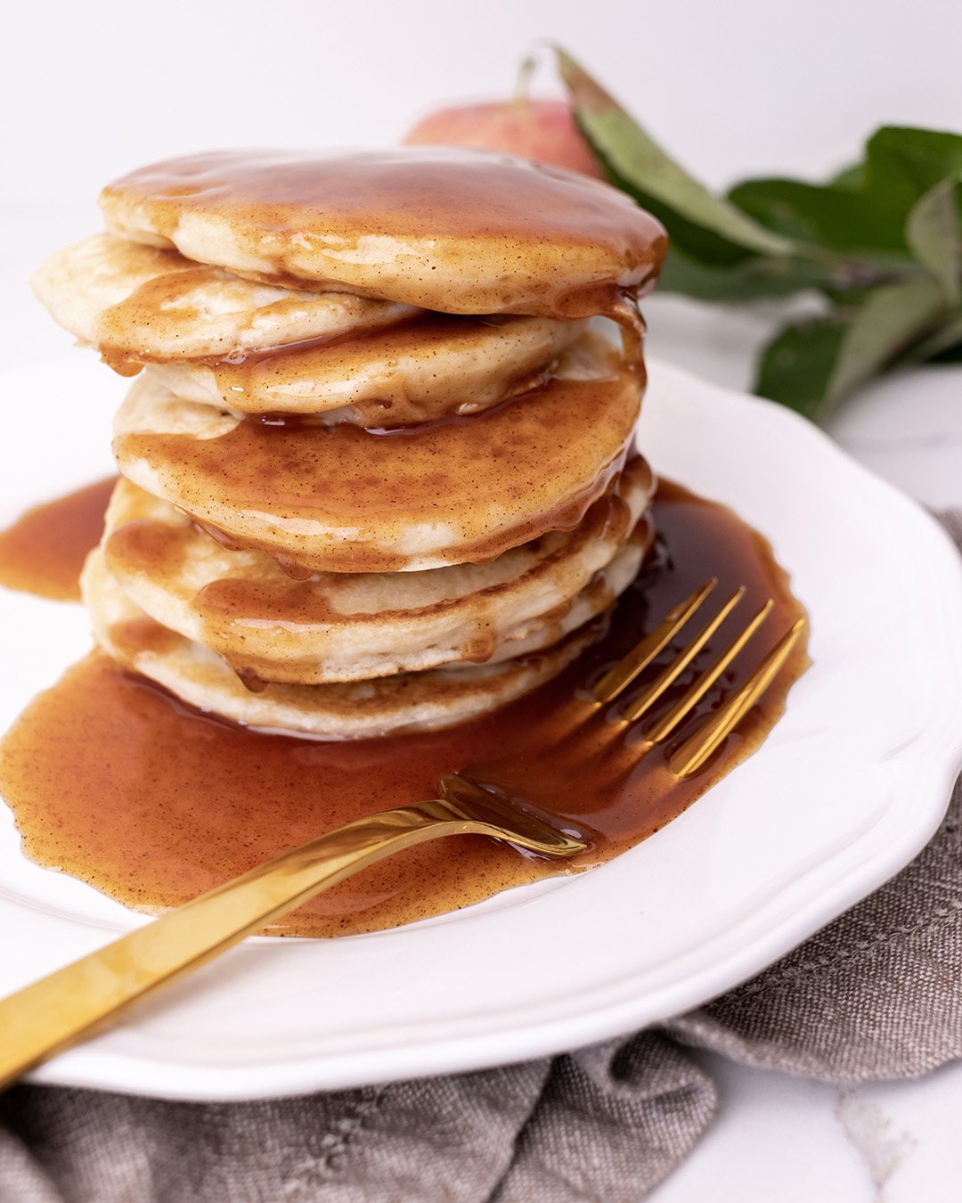 A stack of pancakes smothered in syrup.
