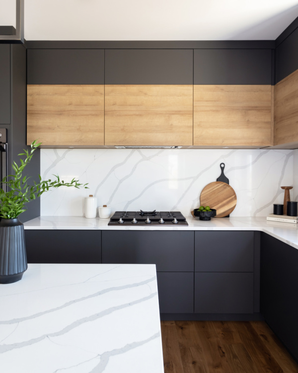 Modern flat panel black cabinetry with continuous grain wood accents.