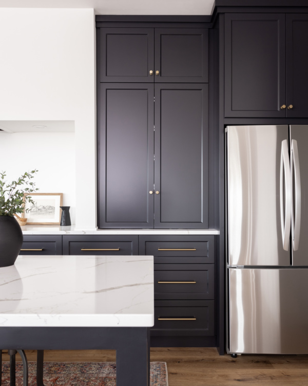 Black kitchen cabinets with gold hardware.