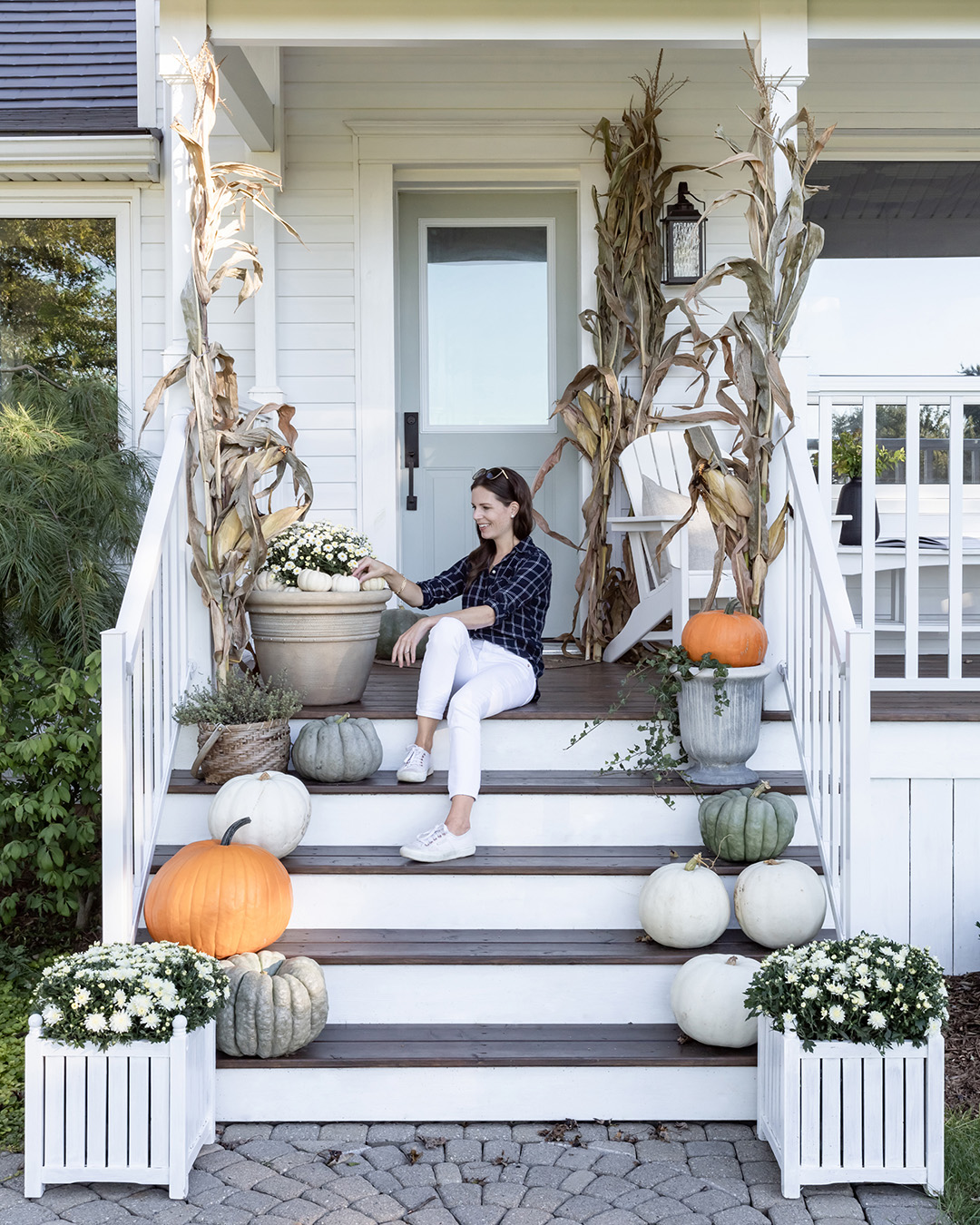 Autumn front porch decorated with white mums and green pumpkins