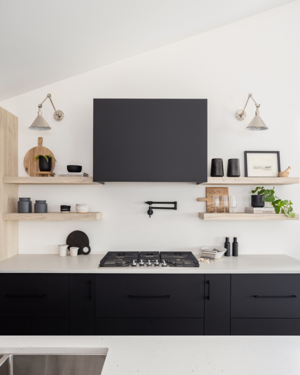 Modern black flat front cabinetry with wood shelves.
