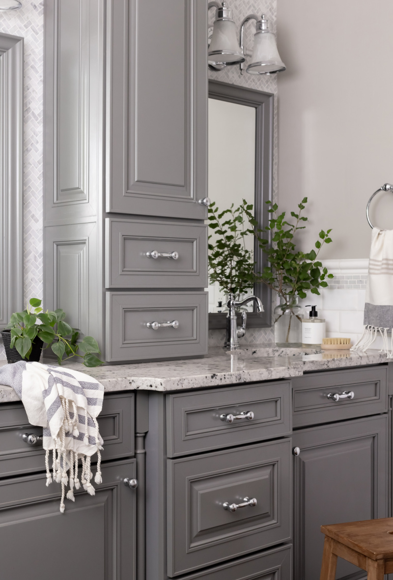 Elegant grey bathroom vanity in a room with heated flooring.
