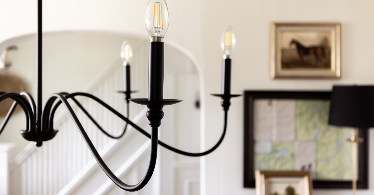 Detailed shot of a traditional black farmhouse chandelier and instructions for how high to hang a ceiling light fixture