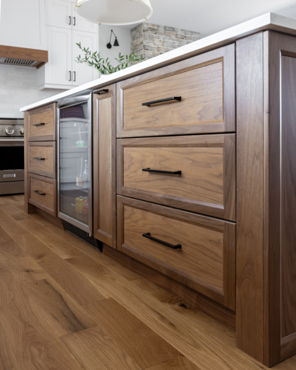 Kitchen wine fridge in a traditional kitchen with white and walnut cabinetry.