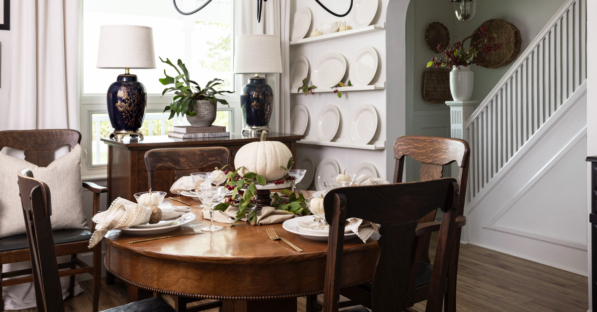 Simple Thanksgiving table decor featuring white pumpkins and gathered greenery.