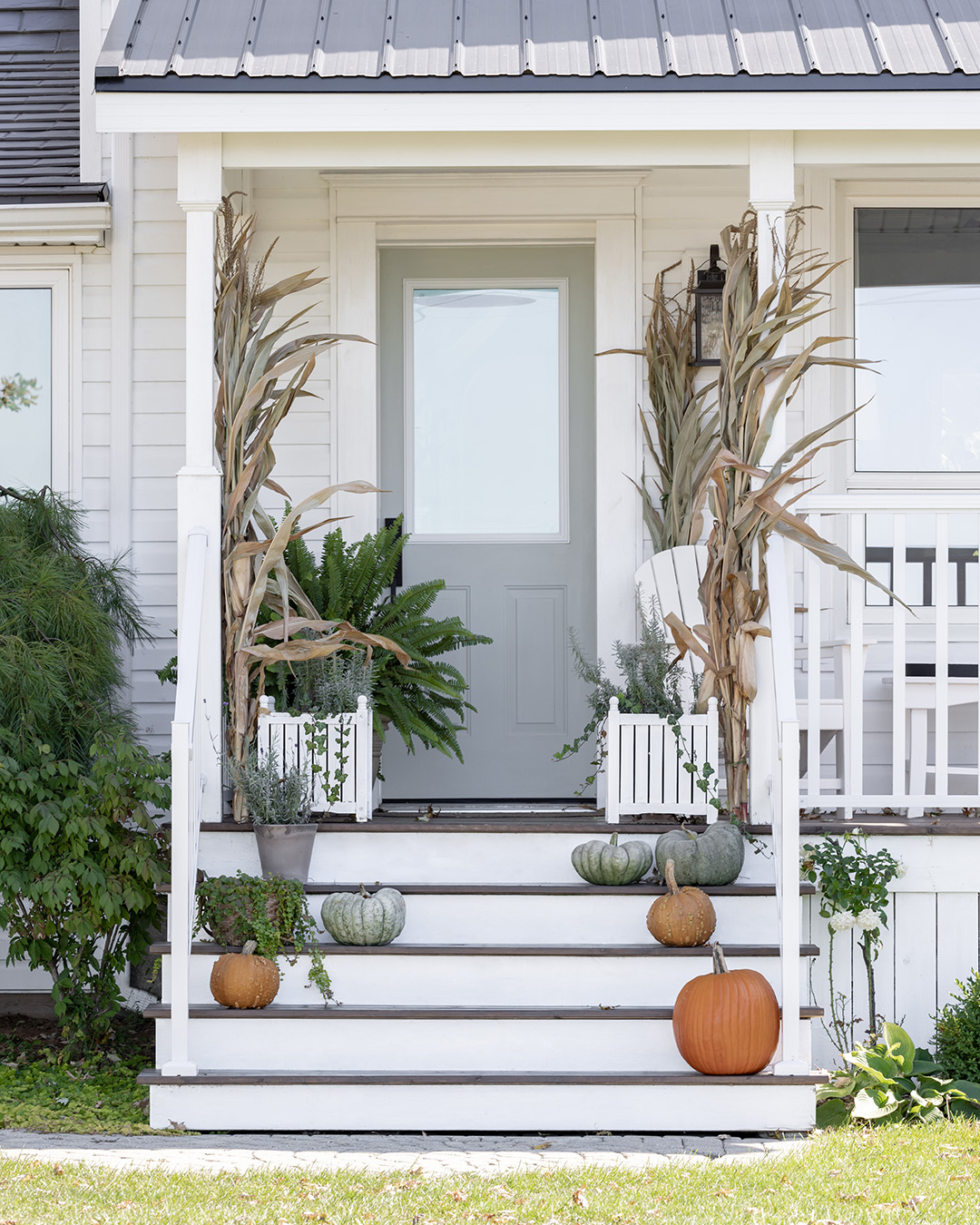 A farmhouse front porch decorated for fall.