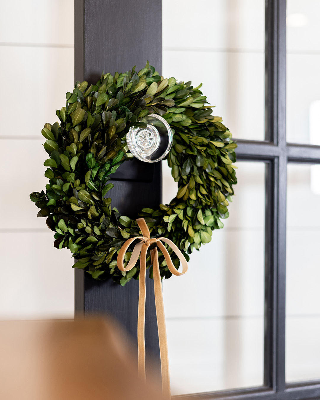A mini boxwood wreath on a doorknob.