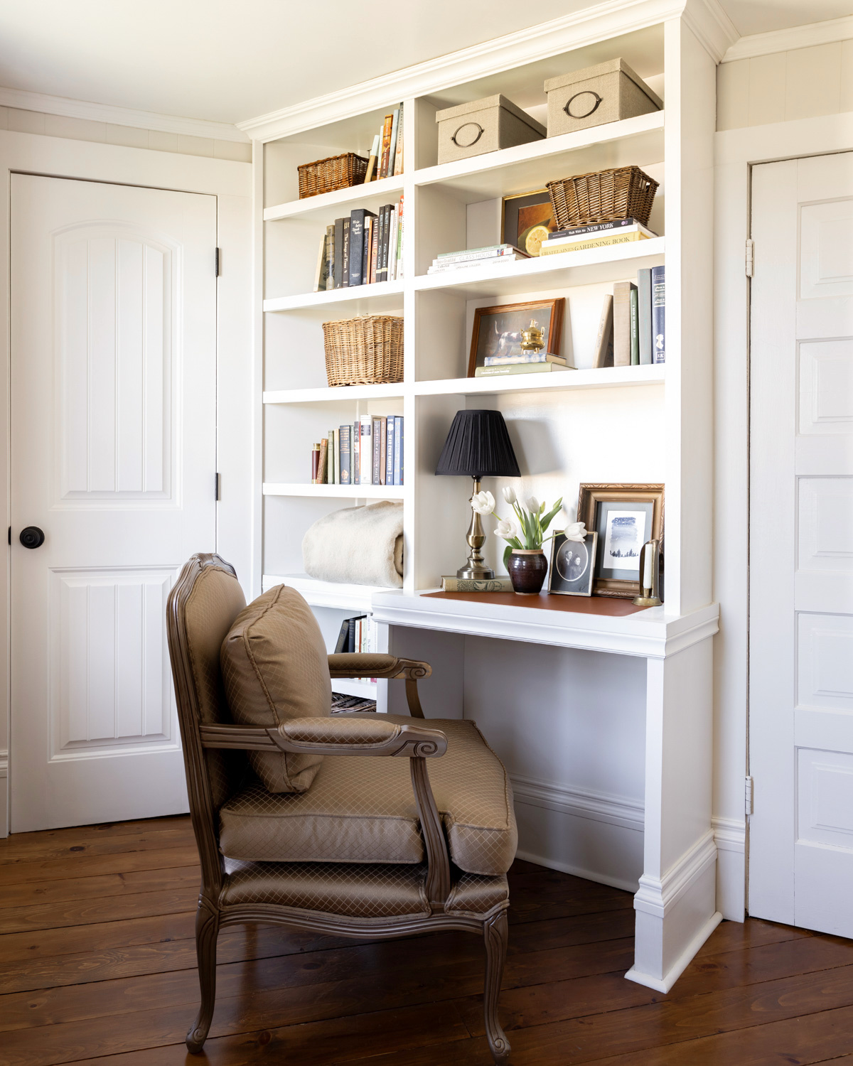 A white built-in bookshelf with a small desk area.