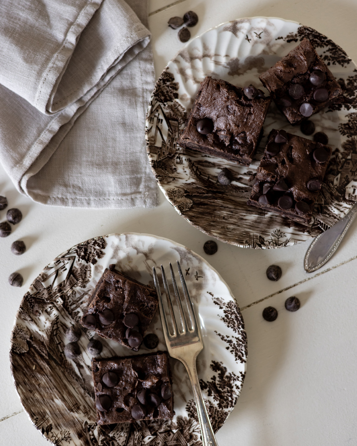 Homemade brownies on brown transfer ware with antique silver forks and linen napkin.