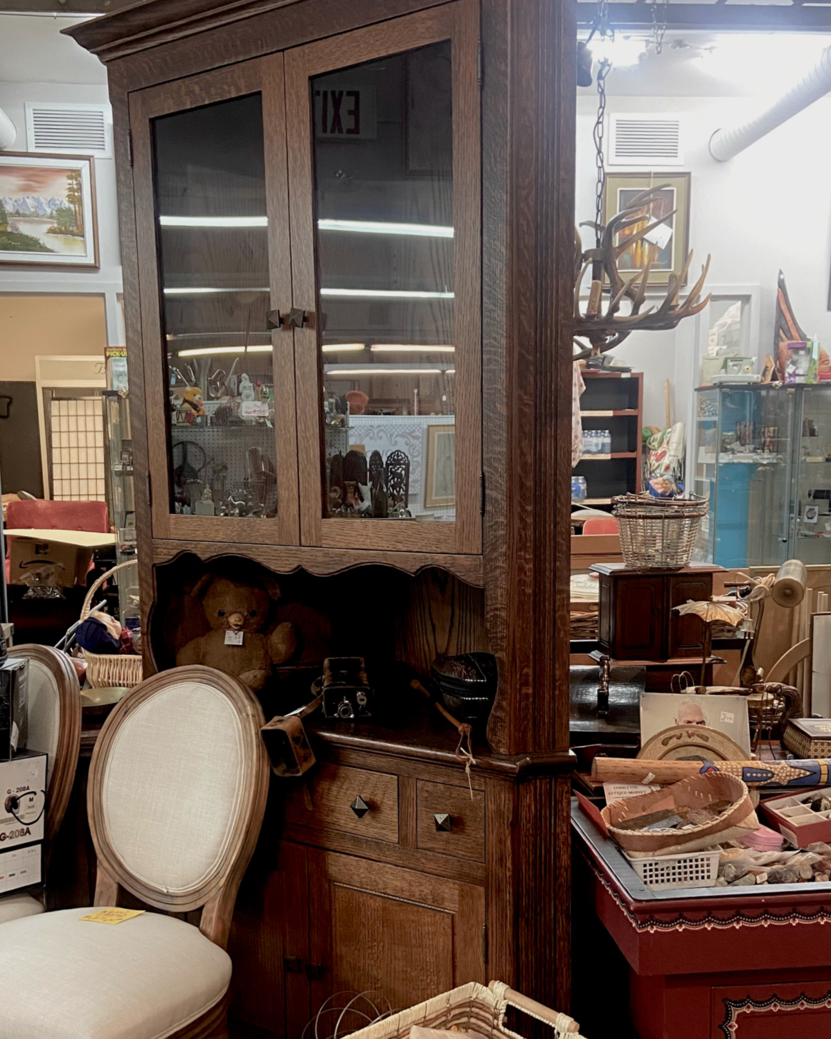 A large antique furniture piece surround by other vintage treasures.