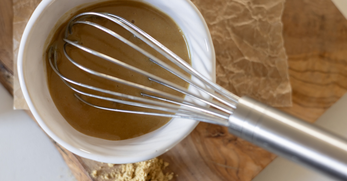 Prepared ginger glaze in a small bowl with a whisk.