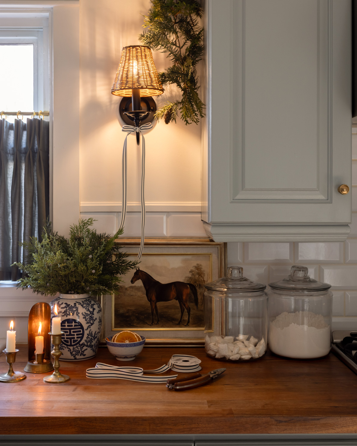Wicker sconce with blue kitchen cabinets in an English Country style kitchen.