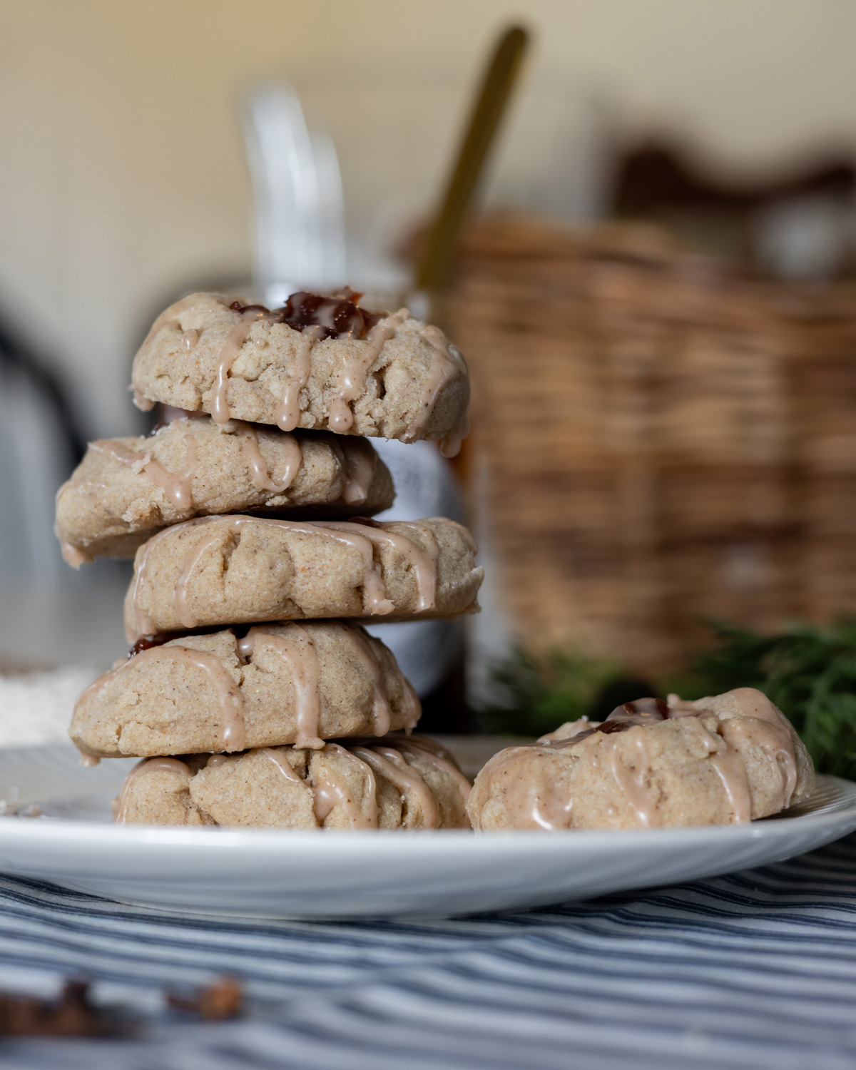 spiced thumbprint cookies stacked on a white plate.