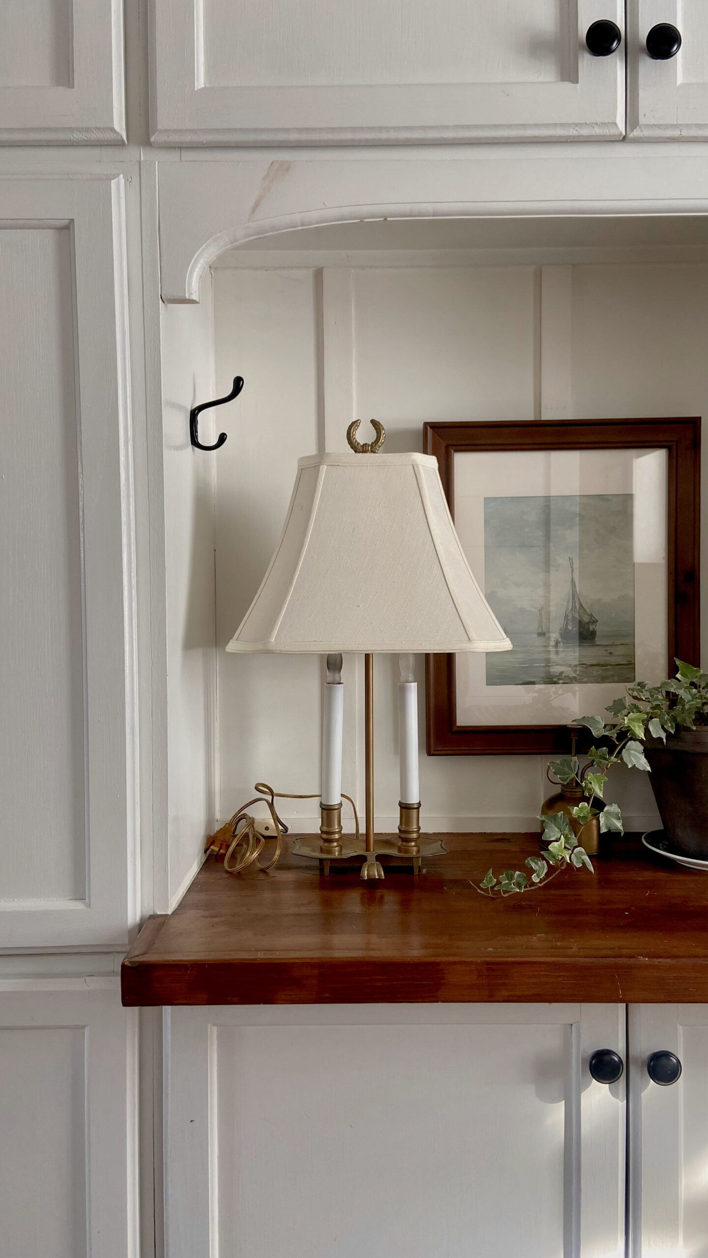 A thrifted lamp with a thrifted shade elevated with lampshade risers.