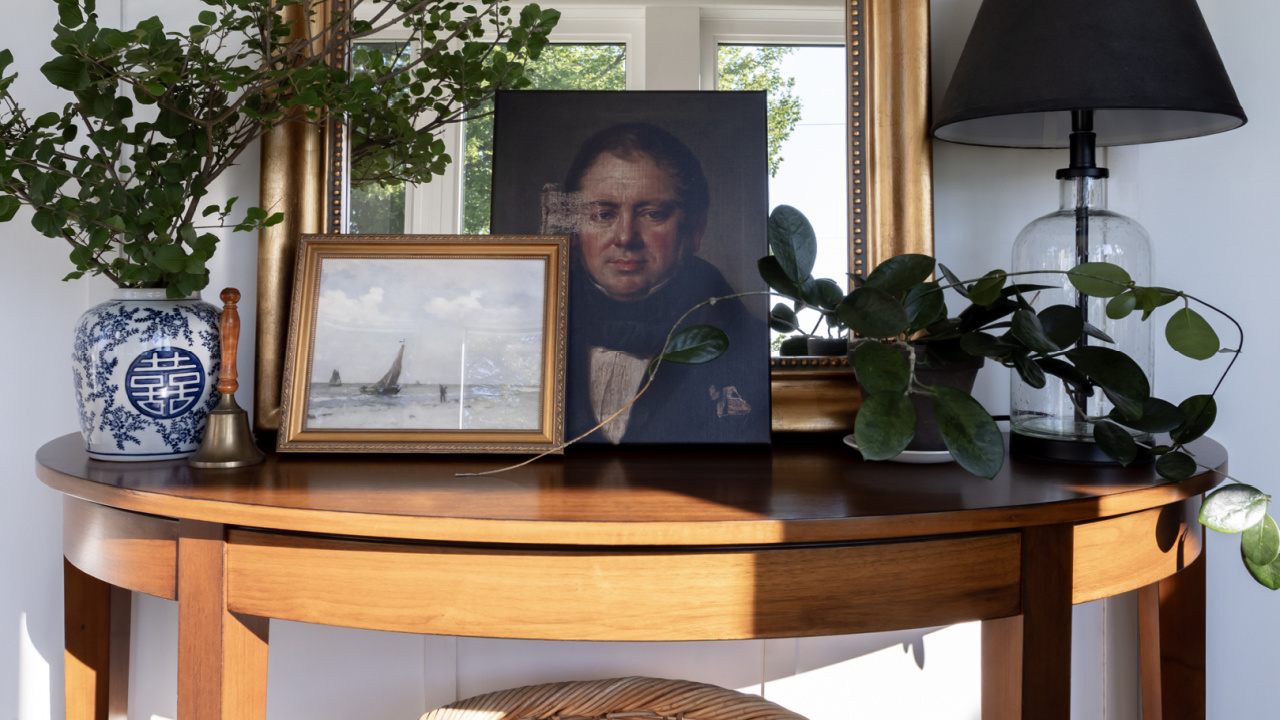 A solid wood demi-lune table decorated in a traditional style.