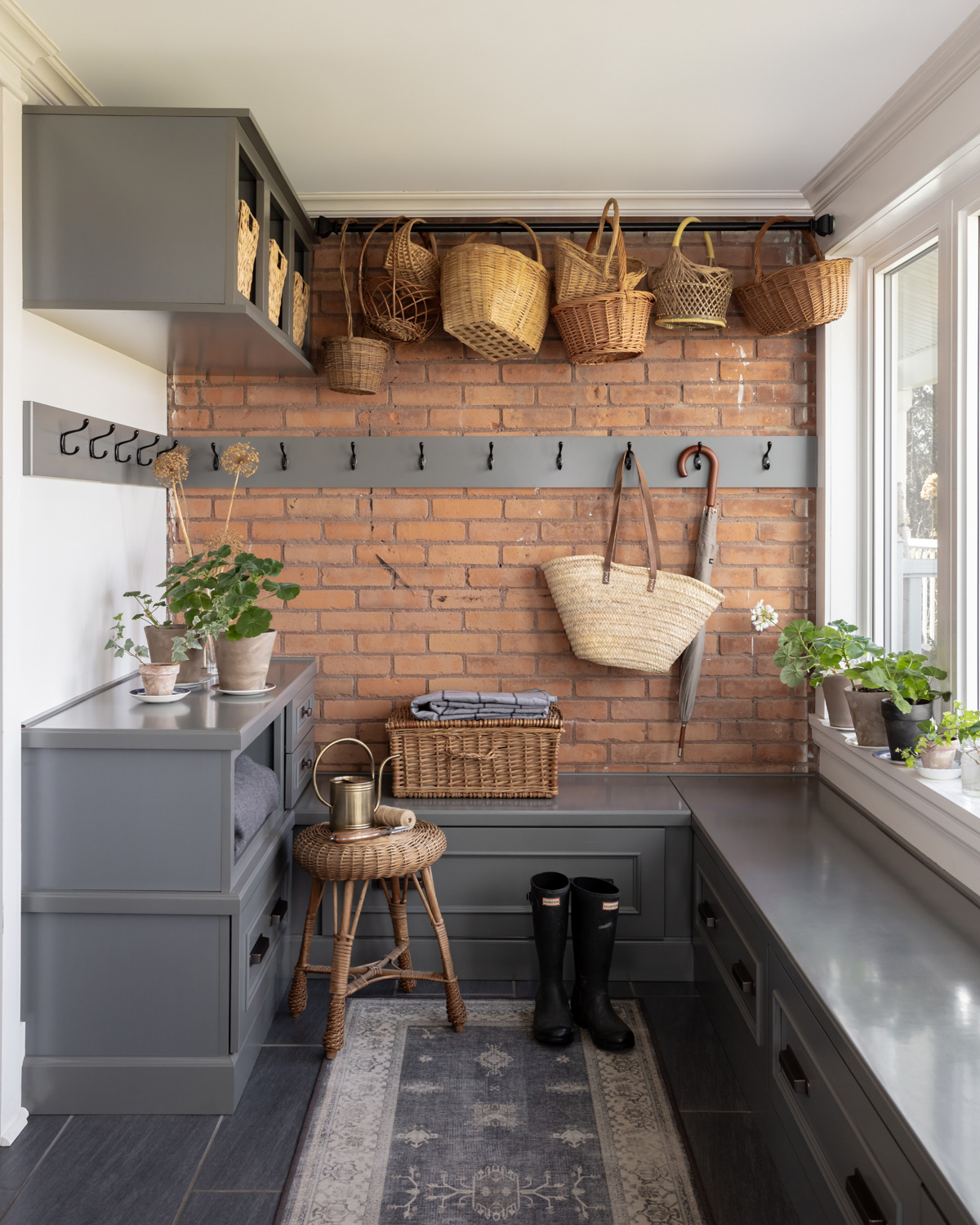 A traditional mudroom with baskets hanging from the ceiling.