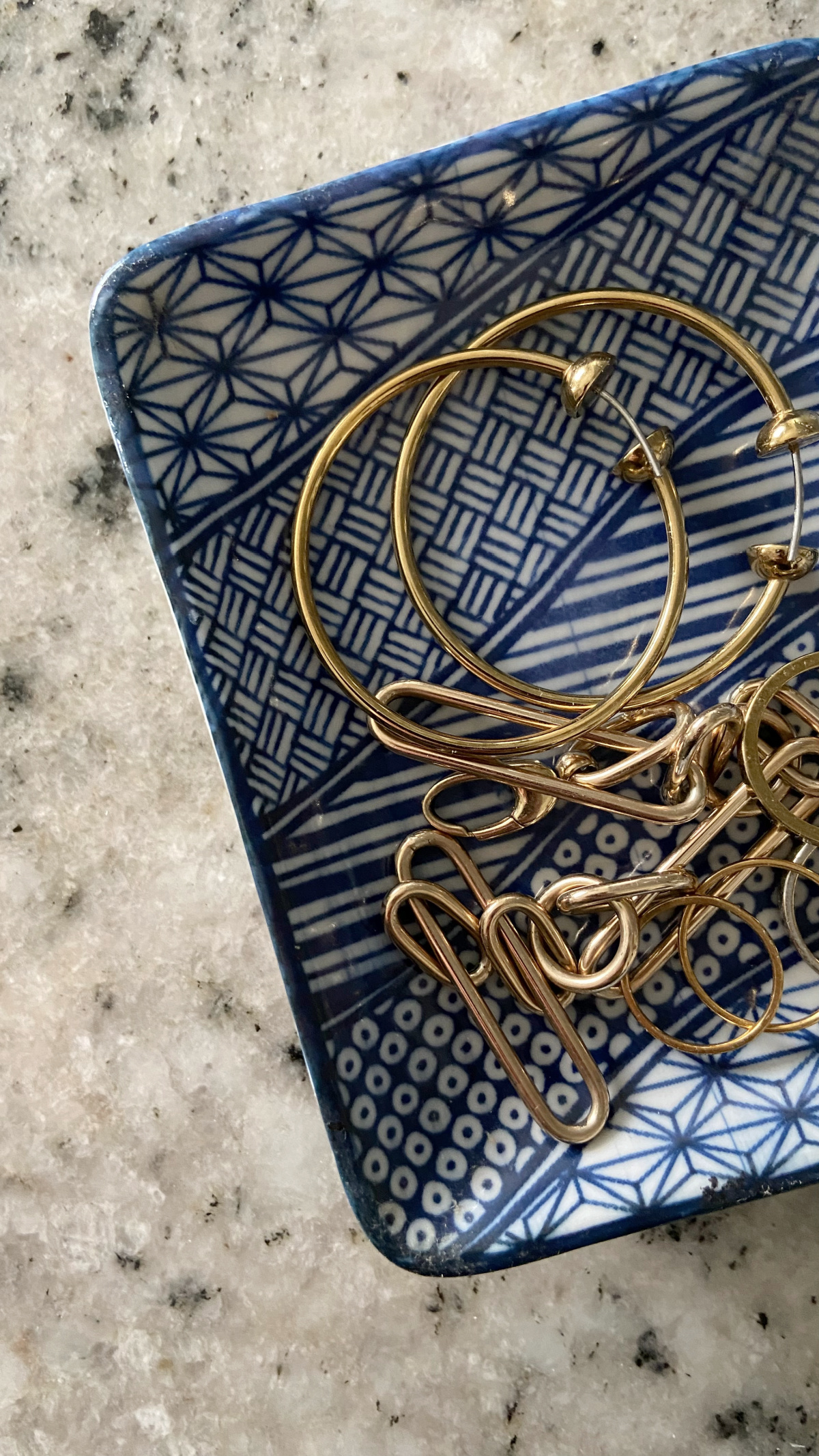 A blue and white vintage dish used as a jewelry tray.