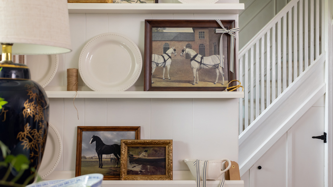 Vintage-inspired prints displayed on a plate rack.
