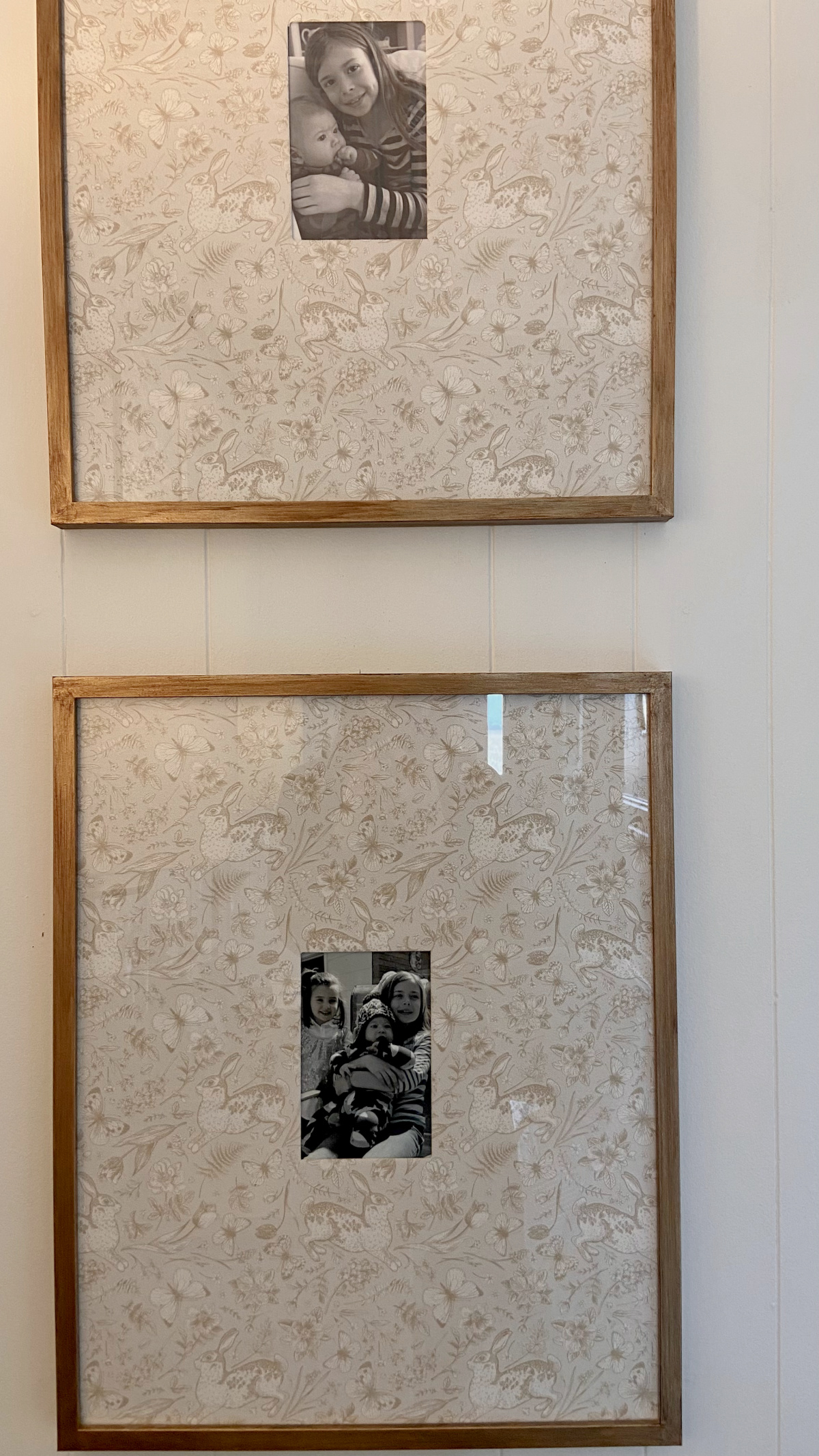 Two frames hanging on a wall with DIY patterned photo mats.