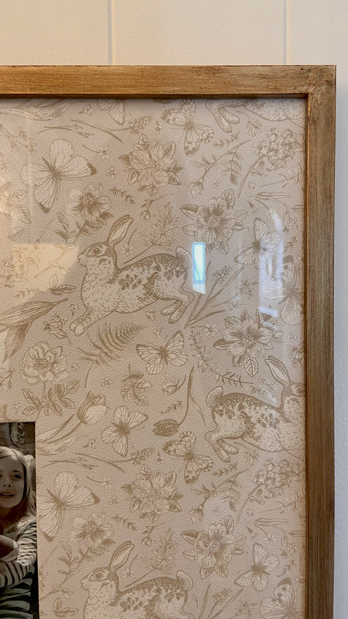 A detailed view of the frame finish and the wallpaper pattern.