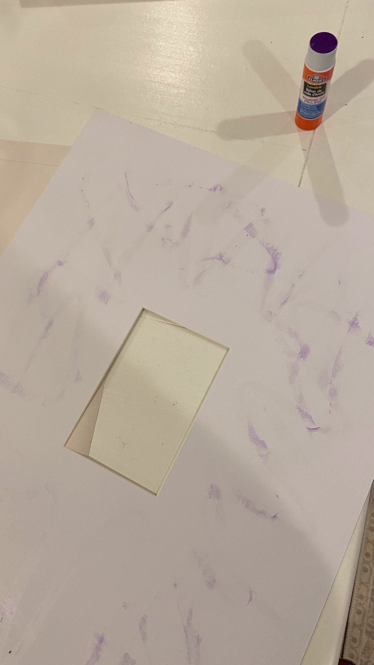 Using glue stick to hold the mat in place on the wallpaper.