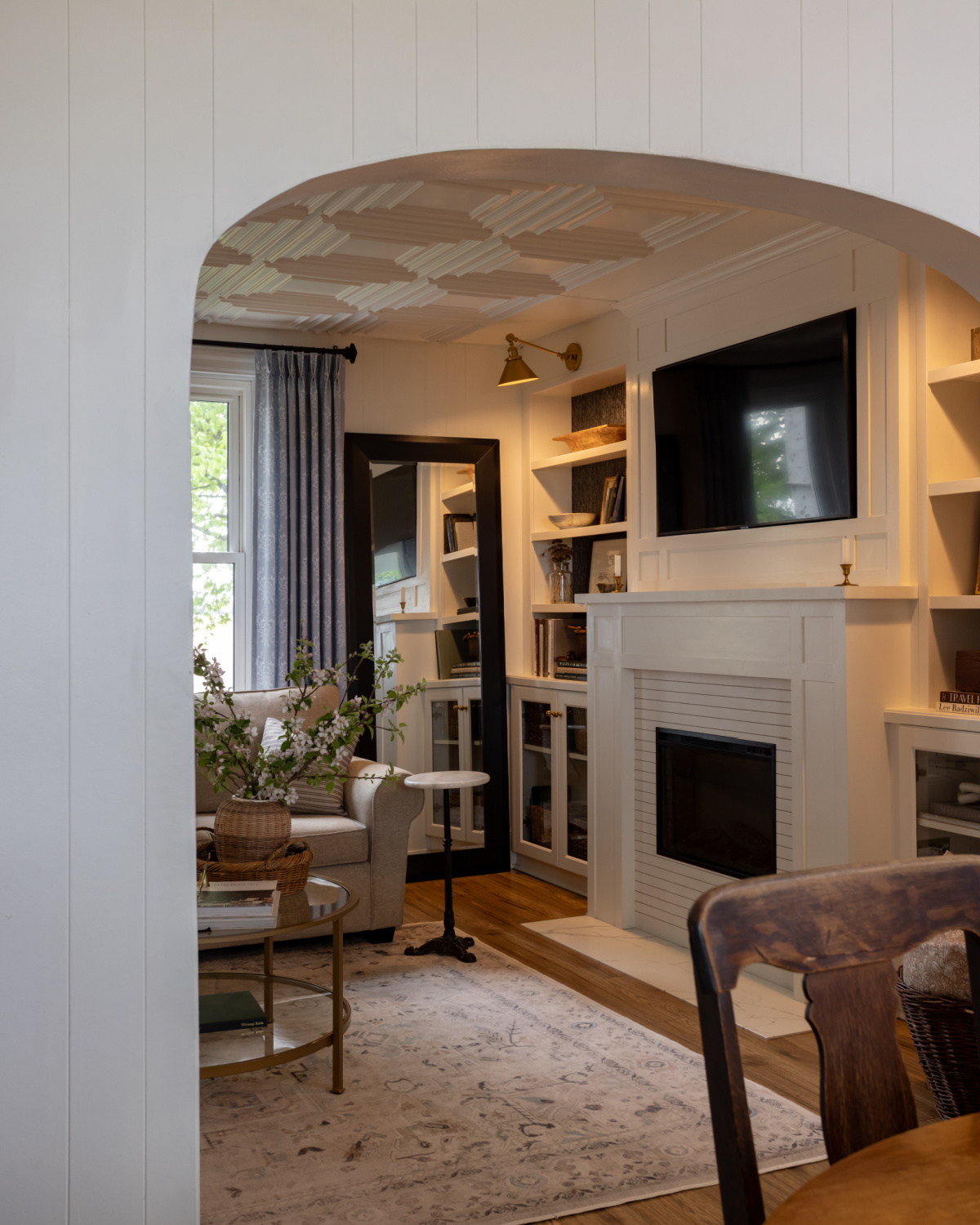 A living room with arched doorway and built-in shelves.