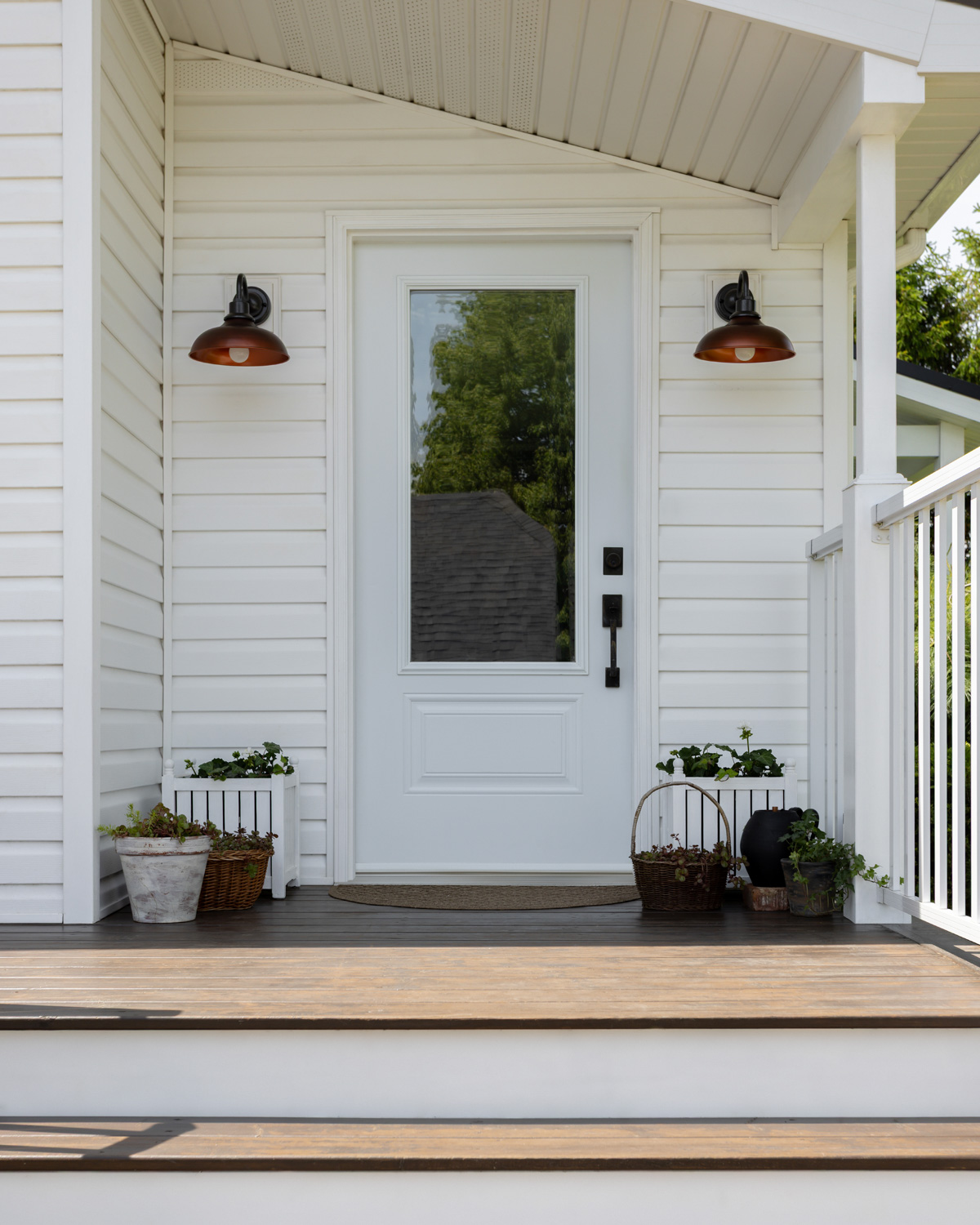 A small porch fountain tucked in among various planters.
