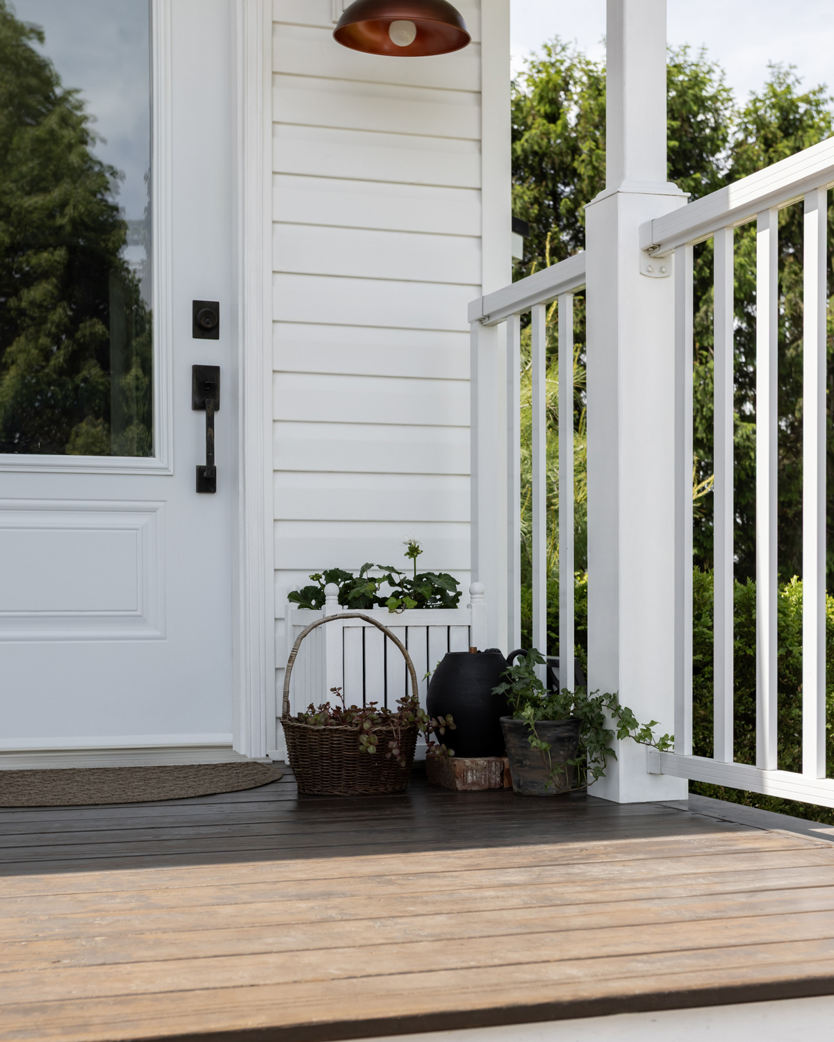 Vintage inspired planters with a small vintage vessel solar fountain on a porch.