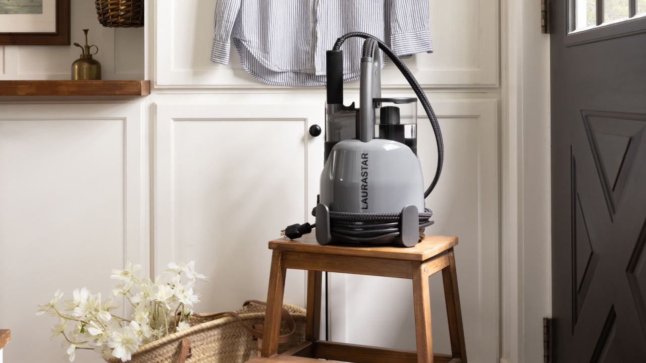 The Laurastar IZZI Plus steamer in front of white cabinetry.
