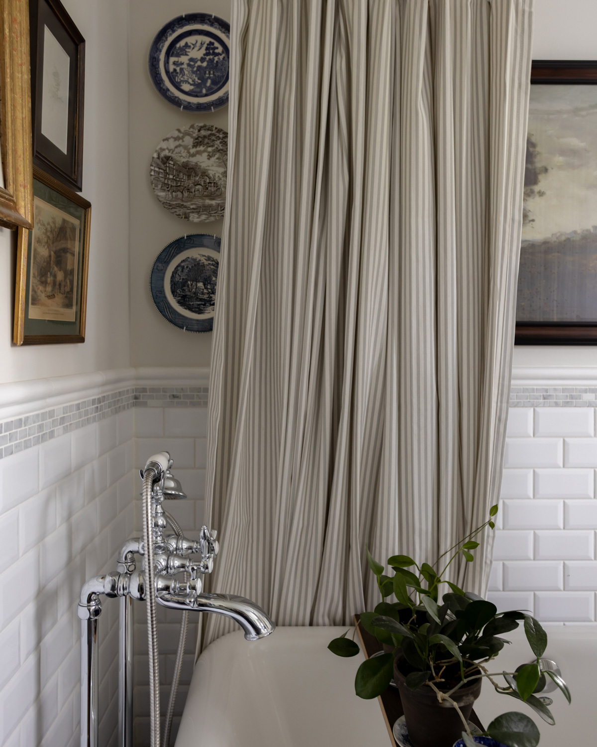 A traditional style bathroom with classic plumbing fixtures and a plate wall.