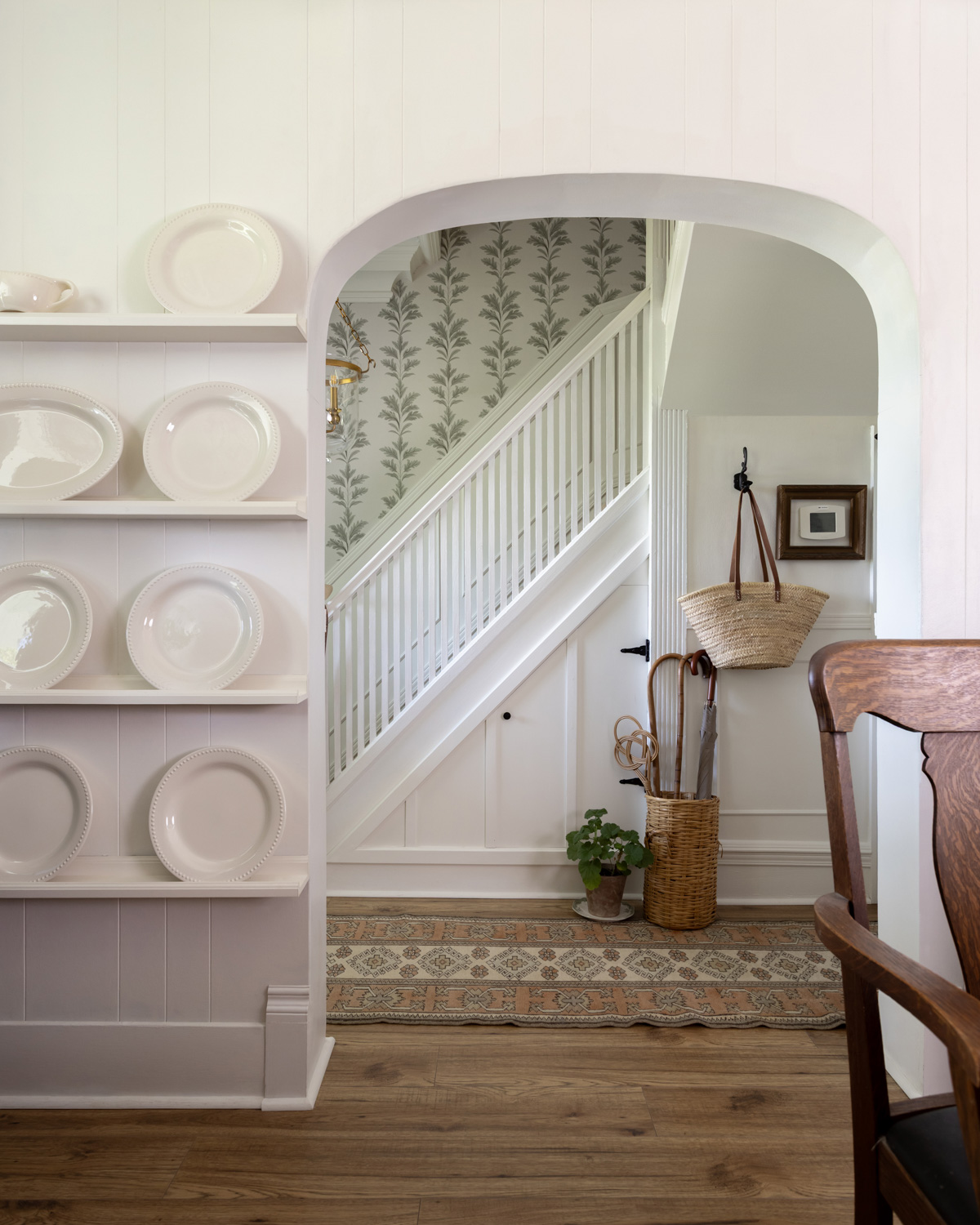 Stairwell with green and white wallpaper.