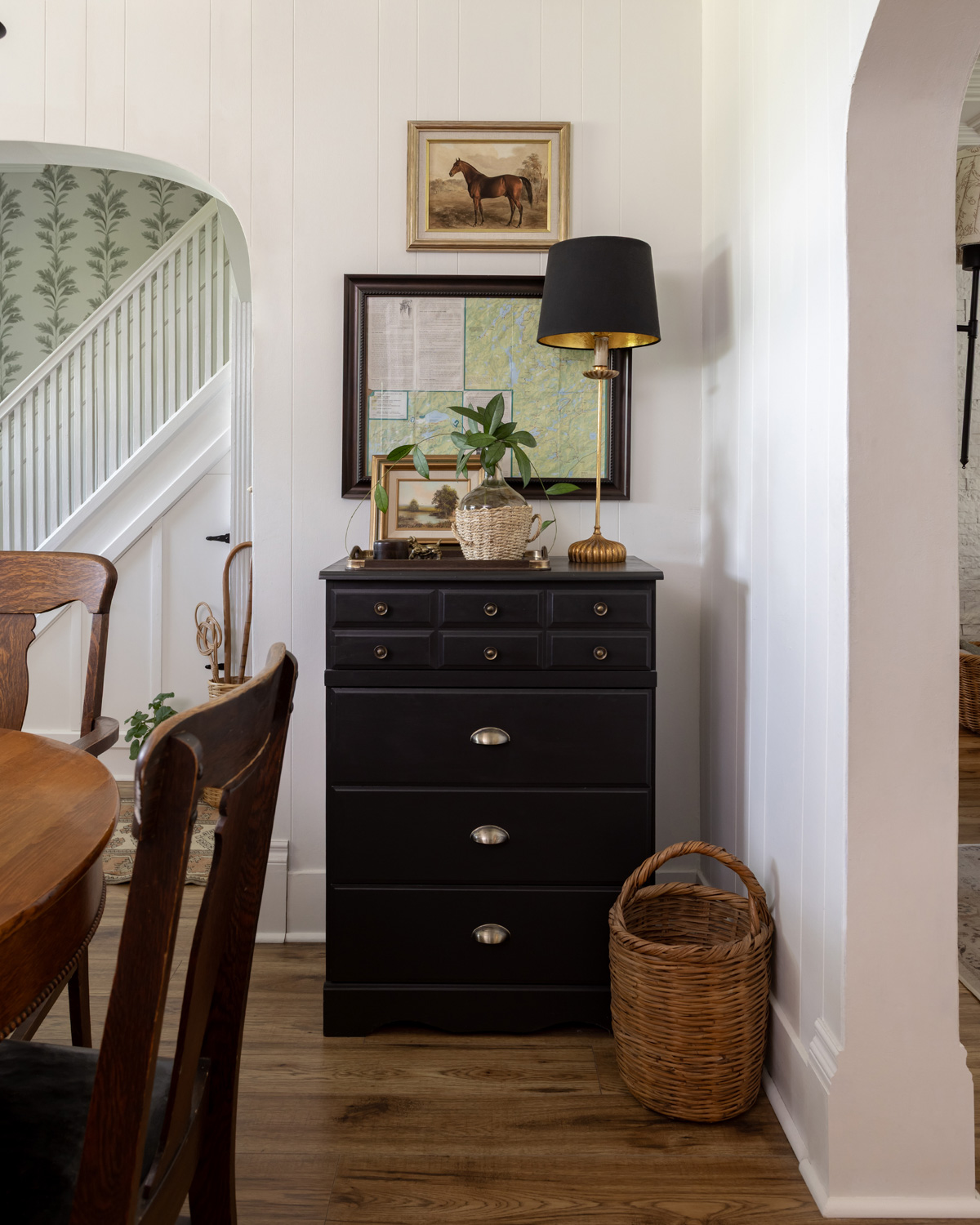Black dresser in dining room with hallway behind.