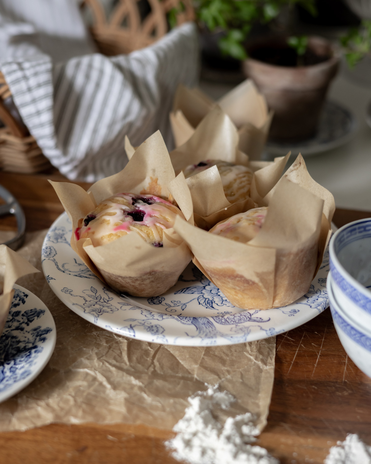 Glazed blueberry muffins in parchment tulip papers.