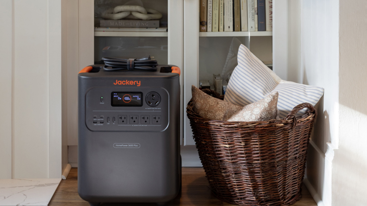 A fully charged Jackery Power Station in front of a built-in cabinet in a living room.