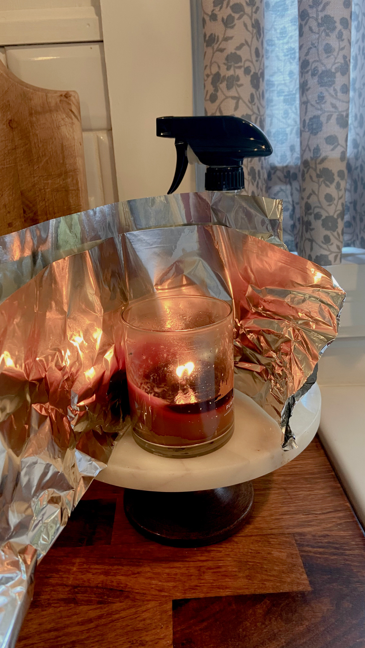 Wrapping the candle in a sheet of aluminum foil.